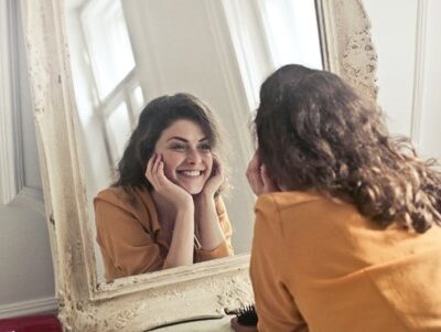 woman smile in front of mirror